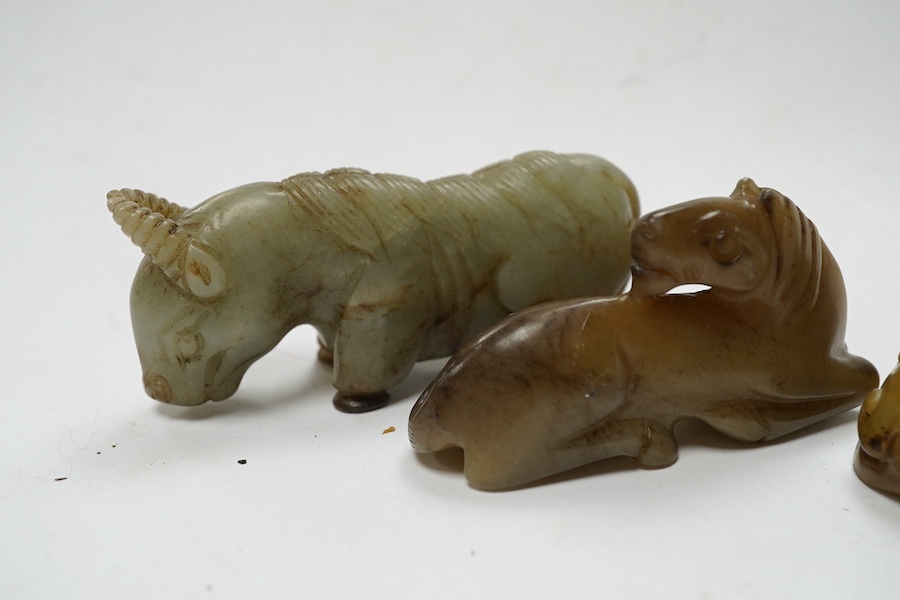 Four Chinese jade carvings, of a horse, cicada, a winged beast, a kneeling man, and a horned beast, longest 7cm. Condition - good